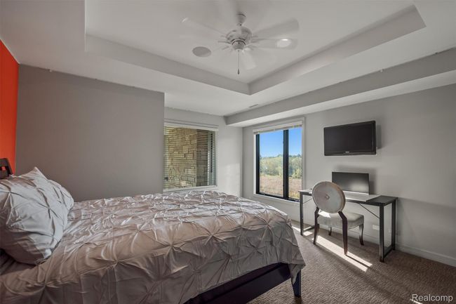 Bedroom with carpet flooring, a raised ceiling, and ceiling fan | Image 45