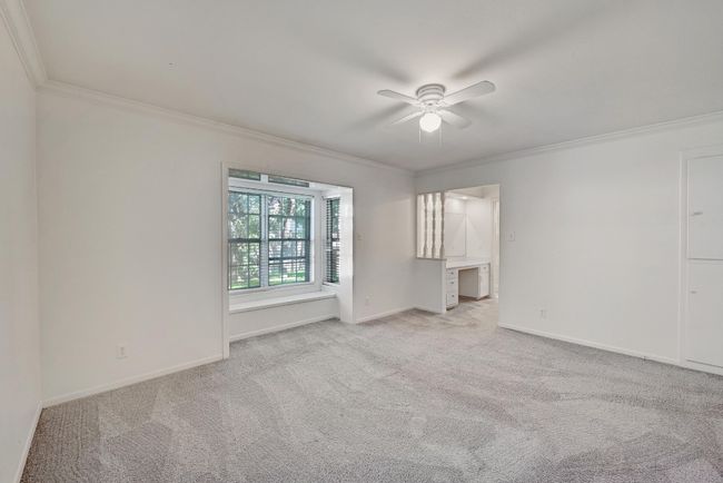 Carpeted empty room featuring baseboards, crown molding, and ceiling fan | Image 17