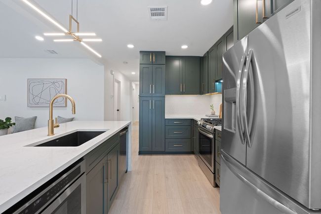 Kitchen with appliances with stainless steel finishes, recessed lighting, light wood-style flooring, light stone countertops, and tasteful backsplash | Image 9