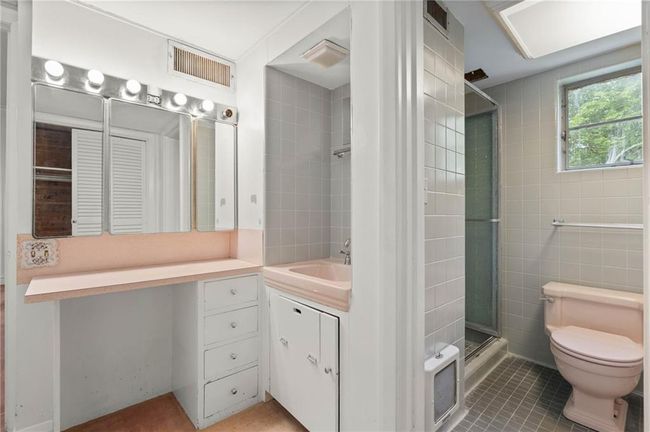 Bathroom featuring tile patterned flooring, toilet, vanity, and a stall shower | Image 18