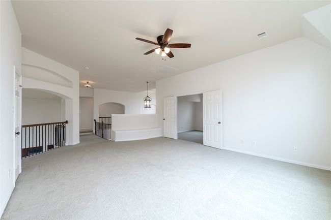 Unfurnished living room featuring ceiling fan, light carpet, and arched walkways | Image 35