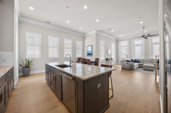 Kitchen with stainless steel dishwasher, dark brown cabinets, ceiling fan, recessed lighting, and open floor plan | Image 10