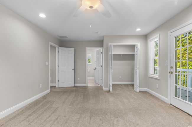 Unfurnished bedroom featuring carpet floors, baseboards, access to exterior, and recessed lighting | Image 26