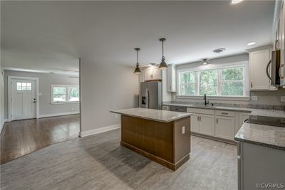 Kitchen featuring a wealth of natural light, appliances with stainless steel finishes, light wood-type flooring, and a kitchen island | Image 2