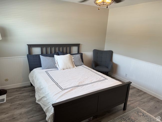 Bedroom featuring wainscoting and wood finished floors | Image 13