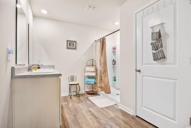 Bathroom with toilet, wood finished floors, vanity, a shower with curtain, and baseboards | Image 28