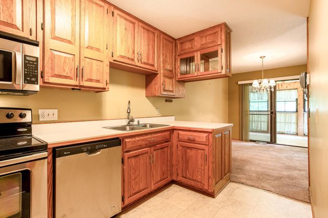 Double-basin sink with pull-down faucet, generous counter space, and open sightlines to the dining area for added functionality and comfort. | Image 11