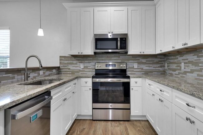 Gorgeous kitchen with ample white cabinets and an abundance of counter space | Image 8