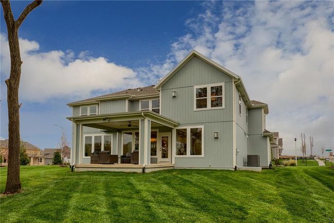 Back of house featuring ceiling fan, a yard, central air condition unit, and a patio | Image 47