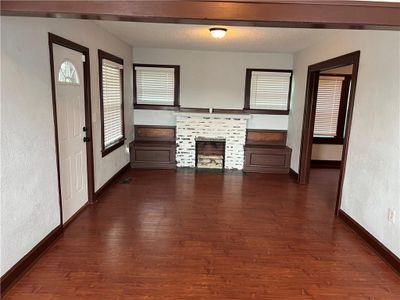 Unfurnished living room featuring atextured ceiling, and dark hardwood / wood-style floors | Image 3