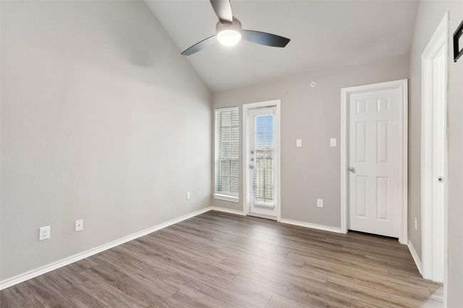 Unfurnished bedroom featuring vaulted ceiling, access to outside, wood finished floors, and ceiling fan | Image 8