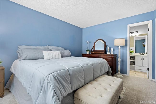Spacious primary bedroom with hallway and bathroom access. | Image 13