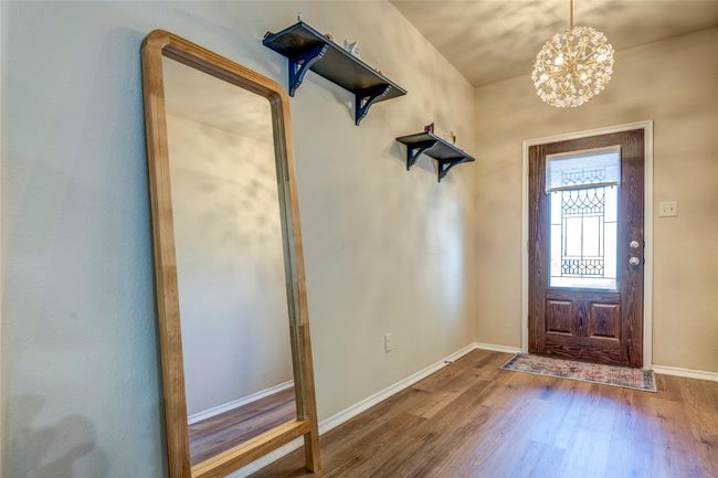 Entrance foyer featuring baseboards, a chandelier, and wood finished floors | Image 5