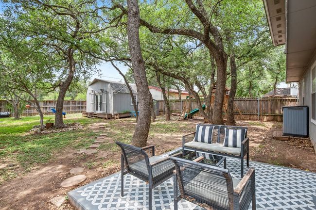 The back patio offers a peaceful spot to relax and enjoy the view of the expansive backyard, with plenty of space for outdoor lounging, dining, or simply soaking in the natural surroundings | Image 26