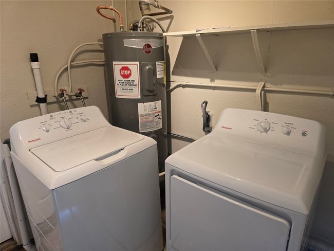 Laundry area featuring water heater, washer and clothes dryer, and a textured wall | Image 4
