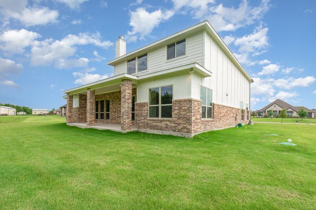 Back of house featuring a chimney, brick siding, a patio area, board and batten siding, and a yard | Image 17