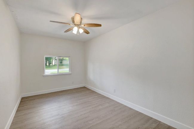Unfurnished room with a ceiling fan, baseboards, and light wood-style flooring | Image 23