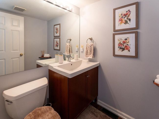 Bathroom with baseboards, visible vents, toilet, and vanity | Image 22