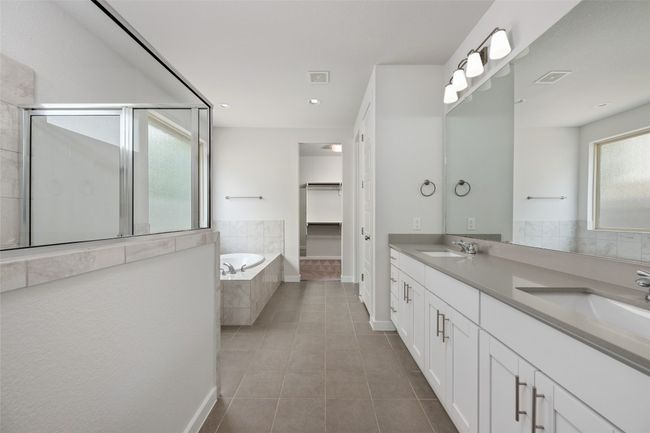 Bathroom featuring tile-patterned flooring, a bath, a shower stall, a double vanity, and recessed lighting | Image 18