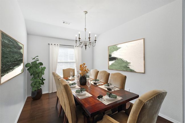 Dining area with dark wood-style floors, an inviting chandelier, visible vents, and baseboards | Image 17