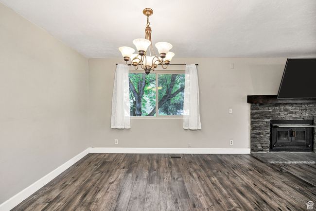 Unfurnished dining area with a chandelier, baseboards, and wood finished floors | Image 10