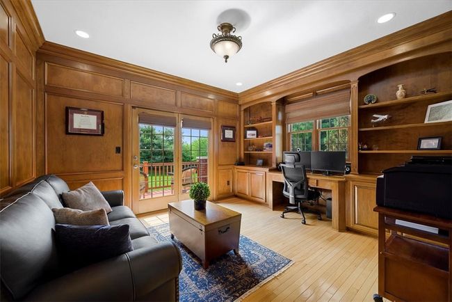 French doors open to this stately first floor judges paneled den with built-in shelving. Doors open to a private deck. | Image 11