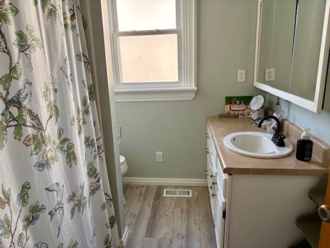 Full bath featuring visible vents, baseboards, toilet, wood finished floors, and vanity | Image 24