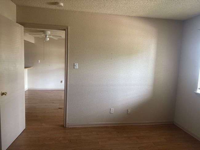 Spare room with dark wood-type flooring, a textured ceiling, and ceiling fan | Image 9