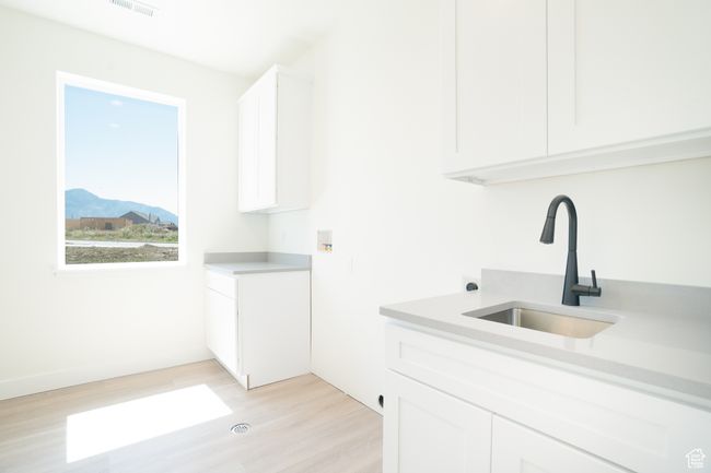 Laundry area featuring cabinet space, light wood-style flooring, washer hookup, and a mountain view | Image 8