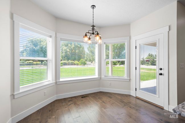 Unfurnished dining area with a chandelier, dark wood-type flooring, and plenty of natural light | Image 11