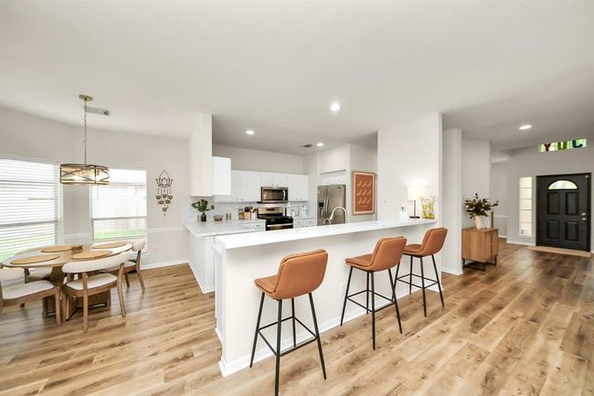 The kitchen includes a long island with space for high bar stools, creating a casual spot to eat, work, or chat—perfectly positioned between the kitchen and living room for easy flow. | Image 15