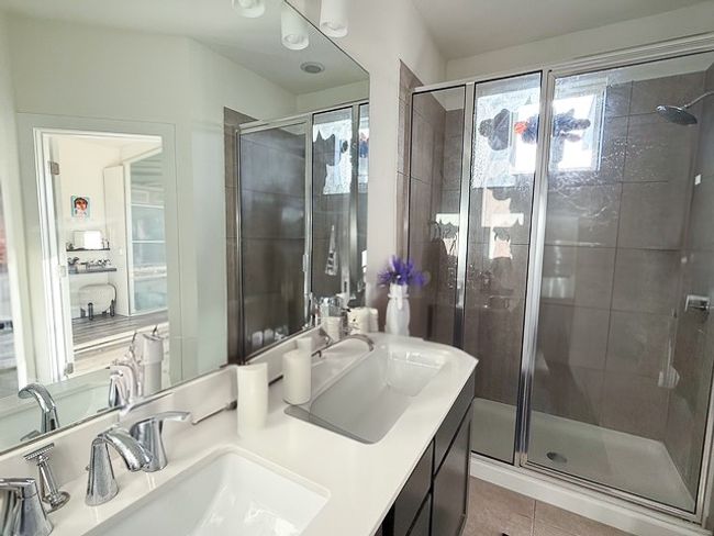 Bathroom with a healthy amount of sunlight, two sinks, and a shower stall | Image 16