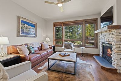 Living room featuring ceiling fan, a fireplace, and dark hardwood / wood-style floors | Image 1