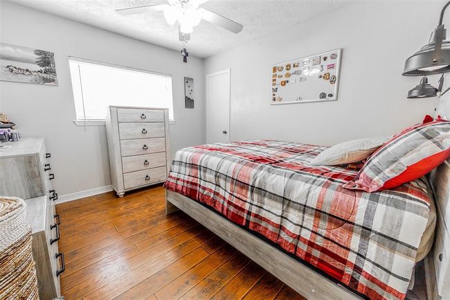 This cozy secondary bedroom features ample space and beautiful flooring. | Image 19