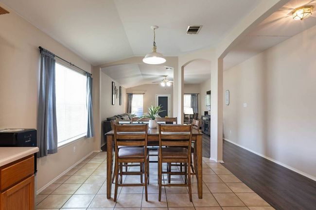 Dining space featuring lofted ceiling, light tile patterned floors, ceiling fan, and arched walkways | Image 7