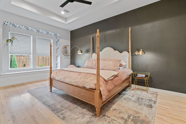 Bedroom featuring wood finished floors, a raised ceiling, a ceiling fan, and recessed lighting | Image 24