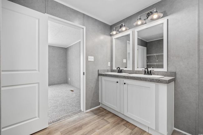 Bathroom with double vanity and wood finished floors | Image 5