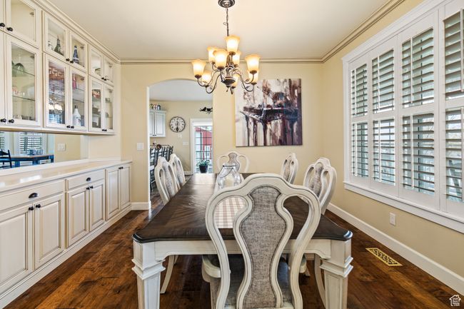 Dining space with a chandelier, dark hardwood / wood-style floors, and crown molding | Image 24