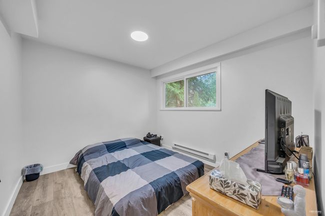 Bedroom with baseboard heating and light wood finished floors | Image 27