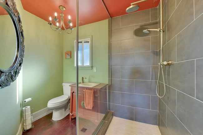 Bathroom with tiled shower, a chandelier, vanity, and wood finished floors | Image 18