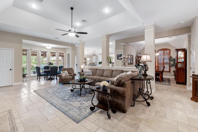 Great room featuring stone tile floors, built in shelves, fireplace, and recessed lighting | Image 8