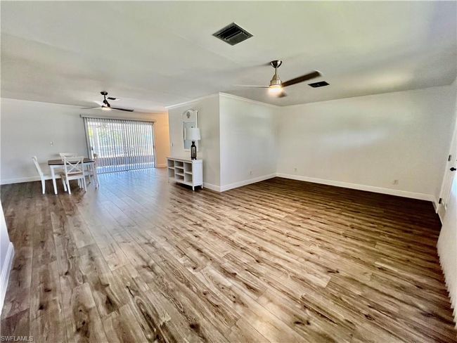 Living room featuring crown molding, LUXURY VINYL PLANK FLOORS. | Image 14