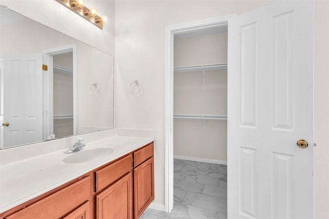 Full bathroom featuring vanity, light marble finish floors, and a spacious closet | Image 19