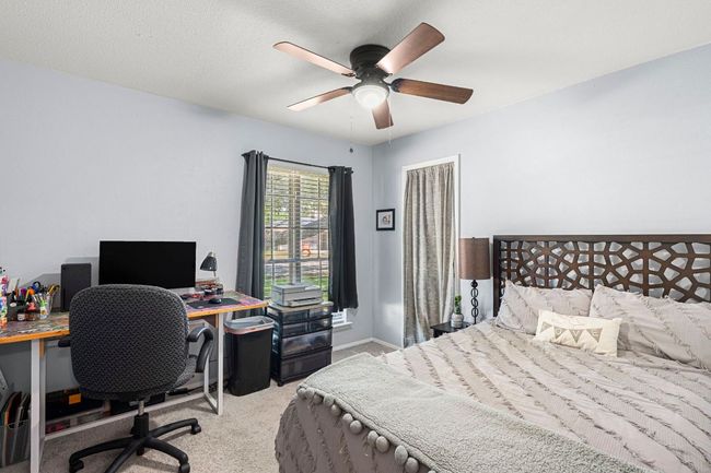Bedroom with light carpet, a desk, a ceiling fan, and baseboards | Image 21