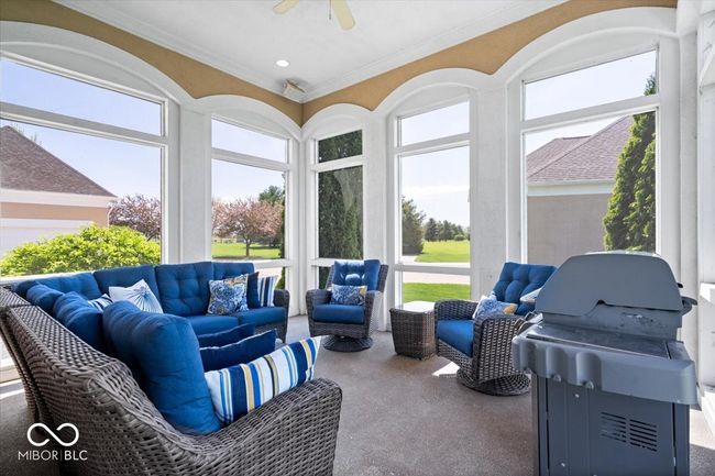 Located off the hearth room, you can escape to unwind on your screened-in patio, overlooking the pond. | Image 24