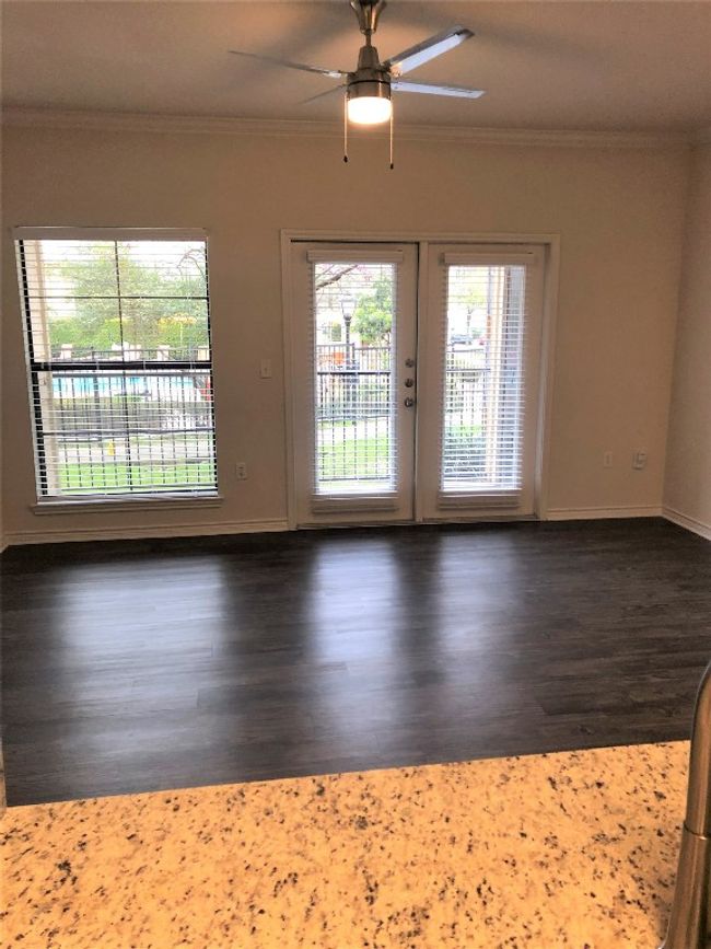 Spare room featuring dark wood finished floors, french doors, crown molding, and a ceiling fan | Image 9