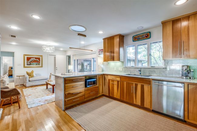 Kitchen featuring sink, light hardwood / wood-style flooring, stainless steel appliances, decorative backsplash, and kitchen peninsula | Image 11