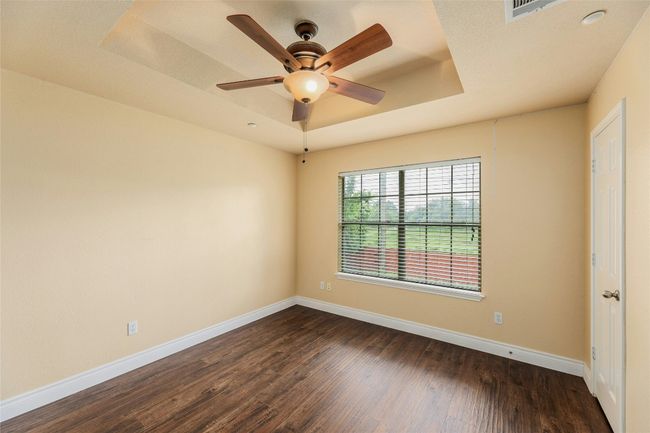 Unfurnished room with a raised ceiling, dark wood-style floors, and a ceiling fan | Image 19
