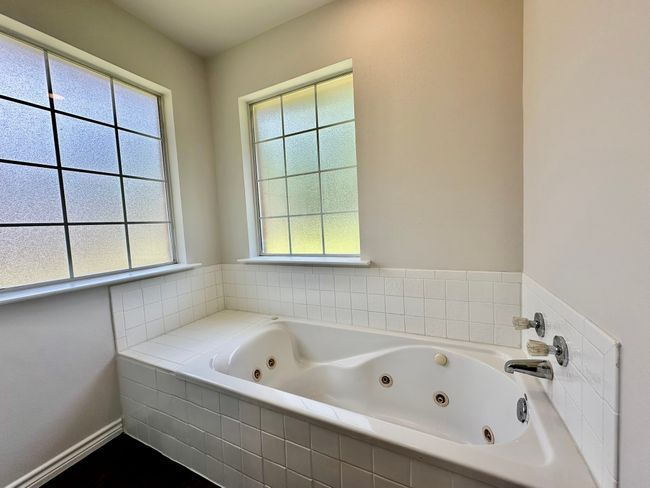Bathroom featuring a tub with jets and plenty of natural light | Image 11