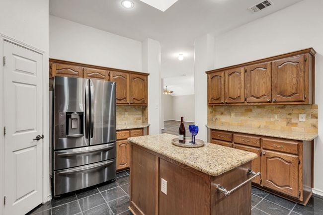 Kitchen featuring a center island, decorative backsplash, stainless steel fridge with ice dispenser | Image 12